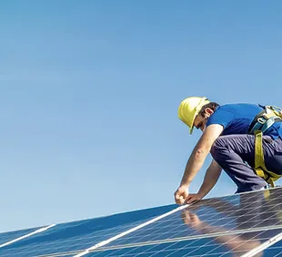 Technician servicing solar panels on a roof